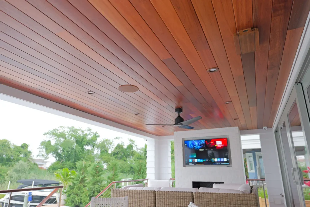 Modern deck with wooden ceiling, painted integrated surround sound speakers, and outdoor TV