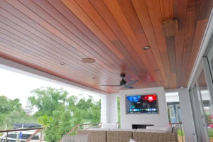 Modern deck with wooden ceiling, painted integrated surround sound speakers, and outdoor TV