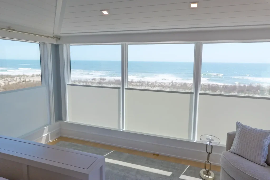 Custom Lutron privacy shades raised in an oceanfront Avalon, NJ home, preserving the ocean view while blocking sightlines from the beach. Home automation avalon NJ