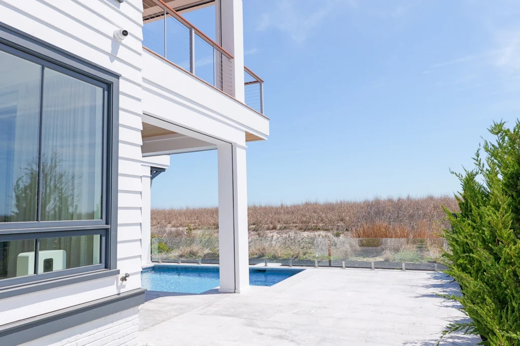 dune-side avalon home with exterior security cameras