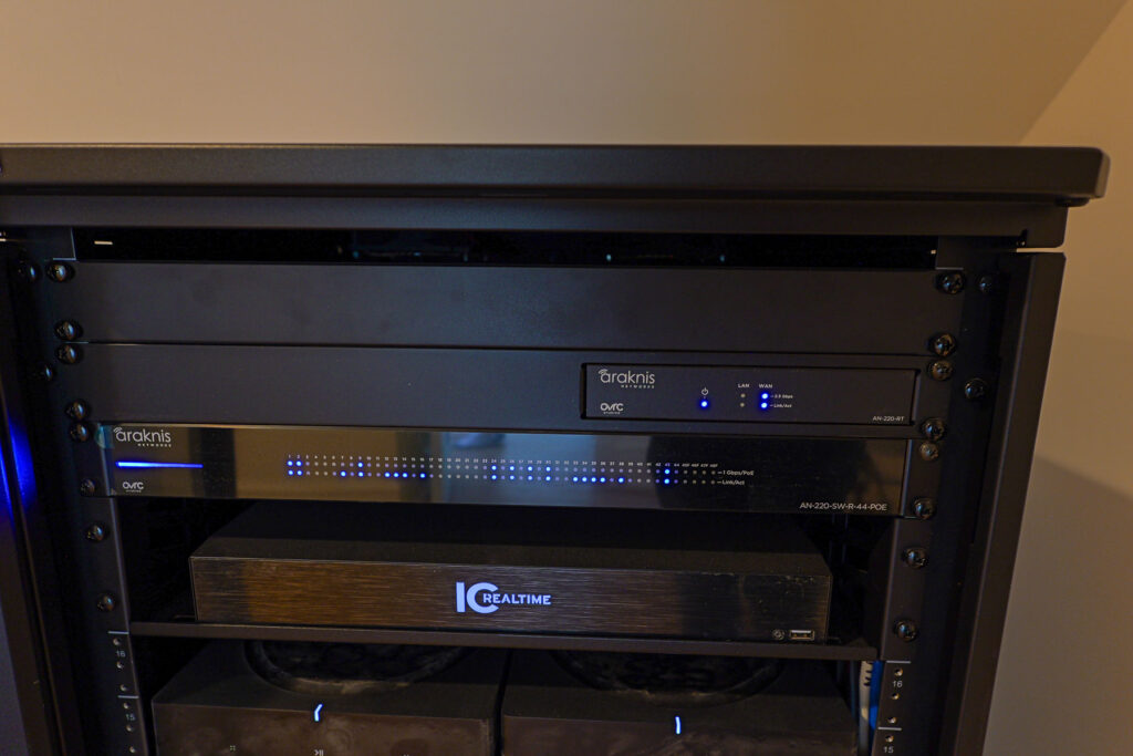 Close-up of Araknis Networks router and PoE switch with IC Realtime DVR rack-mounted in a Stone Harbor, NJ home by Cooltronics.