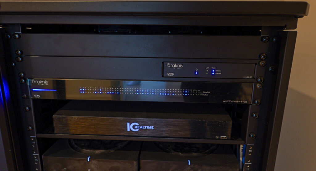 stone-harbor-araknis-switch-ic-realtime-dvr-cooltronics Close-up of Araknis Networks router and PoE switch with IC Realtime DVR rack-mounted in a Stone Harbor, NJ home by Cooltronics.