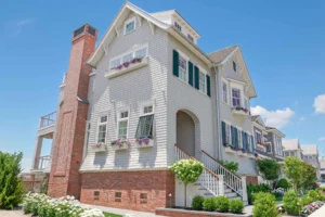 Side elevation view of a Stone Harbor, NJ coastal home showing the multi-level architectural detail and brick chimney.